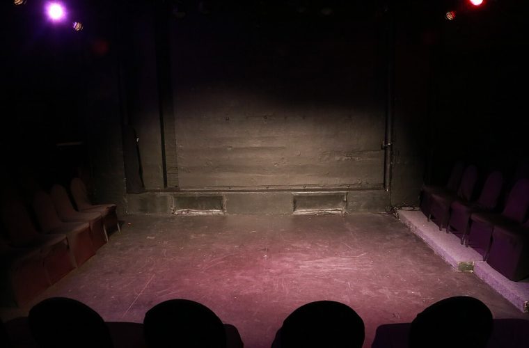 Cabaretier Kor Hoebe op het podium van het Openluchttheater Valkenburg tijdens een zomeravond met publiek